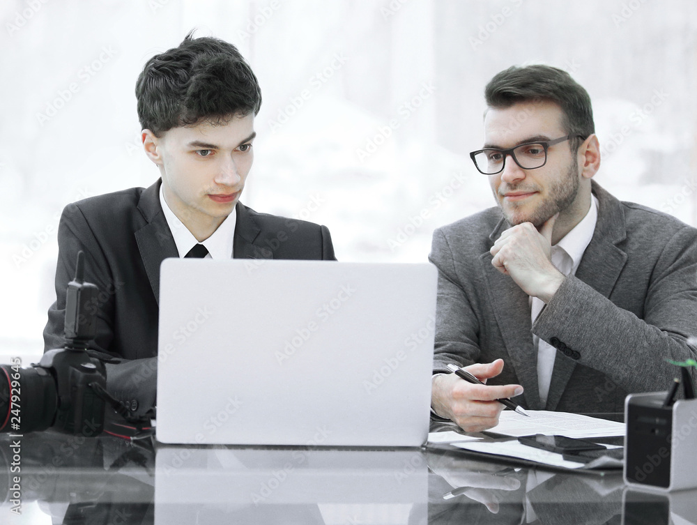 qualified photographers discuss photos to upload files on a laptop . qualified photographers discuss photos to upload files on a laptop .