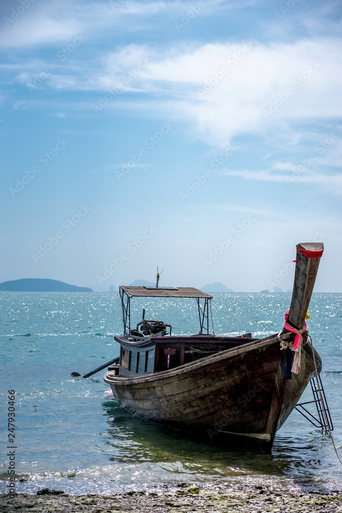 A long tail boat on the tropical white sand beach at Krabi, Thialand. A long tail boat on the tropical white sand beach at Krabi, Thialand.