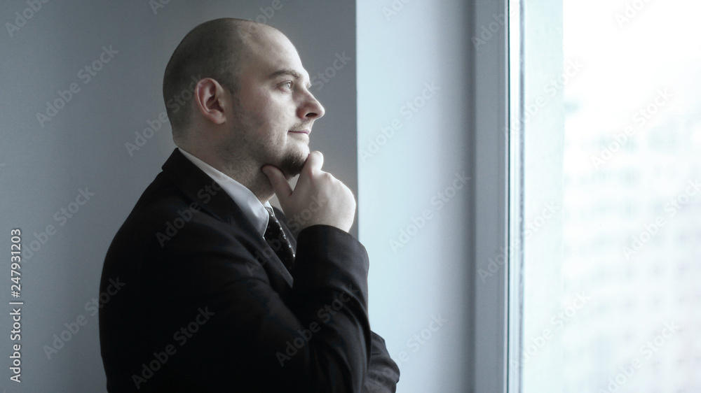 close up. thoughtful businessman looking in the office window close up. thoughtful businessman looking in the office window