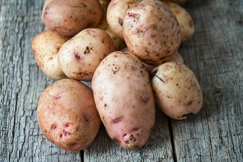 Potatoes on the rough wooden boards of a village table
