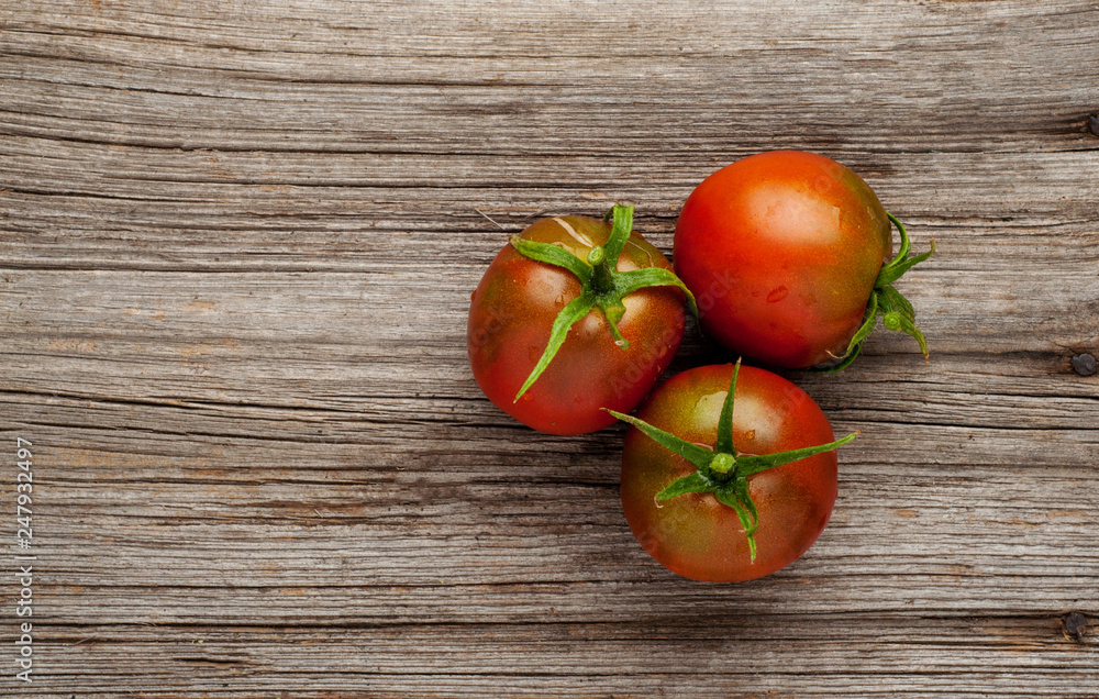 Fresh ripe tomatoes on wooden background. Top view or flat lay Fresh ripe tomatoes on wooden background. Top view or flat lay