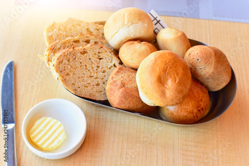 Bread Assortment Isolated on Wooden Table with Knife and Butter
