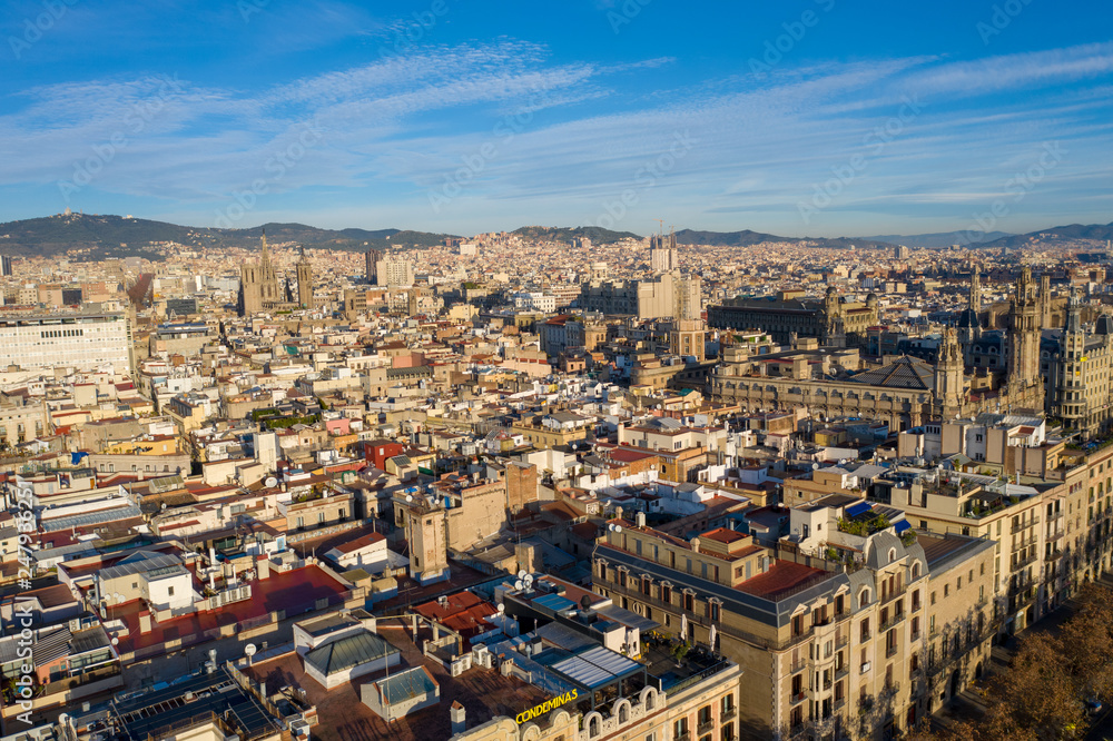 Aerial; drone view of old spanish buildings in Barcelona illuminated by warm morning light; old roofs of low houses in Barcelonetta area; Sunny day in touristic capital of province of Catalonia, Spain