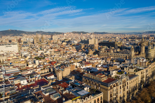 Aerial; drone view of old spanish buildings in Barcelona illuminated by warm morning light; old roofs of low houses in Barcelonetta area; Sunny day in touristic capital of province of Catalonia, Spain