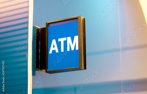 Modern square shape ATM sign in department store. White text on blue background.