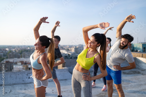 Group of happy fit friends exercising outdoor in city