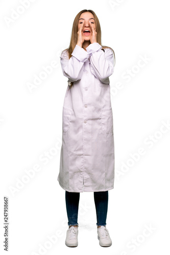 Full body Young doctor woman shouting and announcing something on isolated background © luismolinero