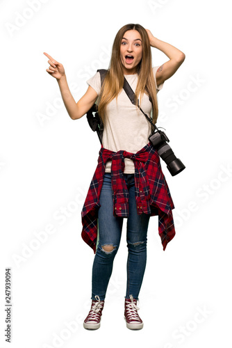 Full body Young photographer woman pointing finger to the side and presenting a product on isolated background