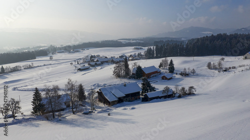 aerial flight over snow covered german village in winter