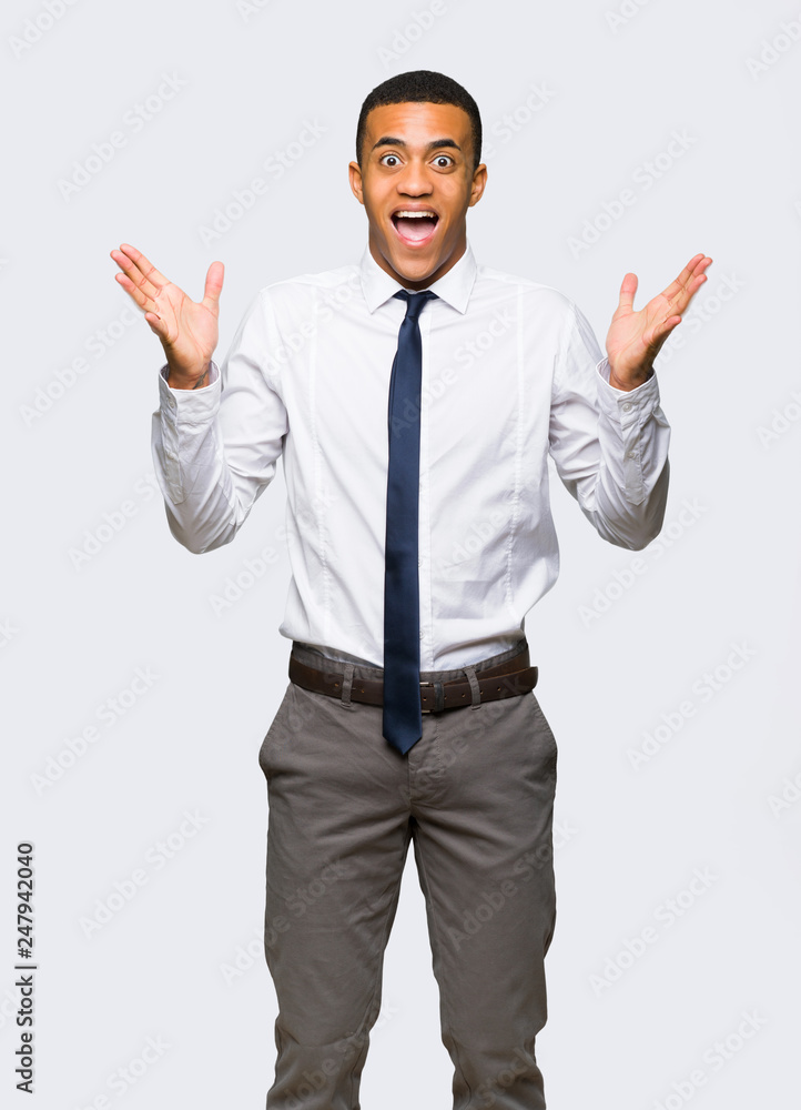 Young afro american businessman with surprise and shocked facial expression on isolated background Young afro american businessman with surprise and shocked facial expression on isolated background