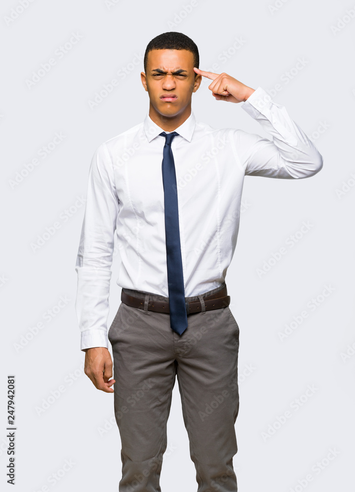 Young afro american businessman making the gesture of madness putting finger on the head on isolated background Young afro american businessman making the gesture of madness putting finger on the head on isolated background