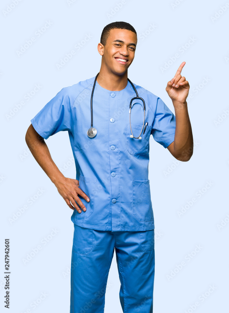 Surgeon doctor man showing and lifting a finger in sign of the best on isolated background Surgeon doctor man showing and lifting a finger in sign of the best on isolated background