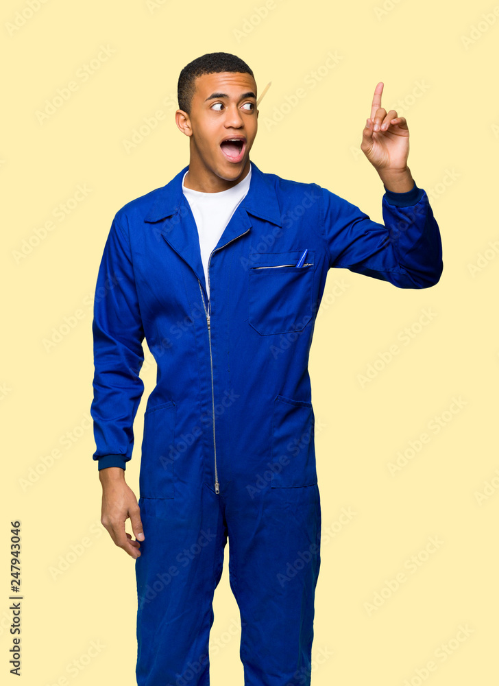 Young afro american worker man intending to realizes the solution while lifting a finger up on isolated background Young afro american worker man intending to realizes the solution while lifting a finger up on isolated background