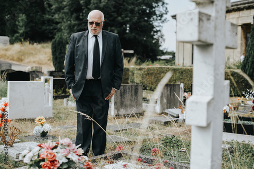 Quadro em tela Lonely widower mourning at the graveyard