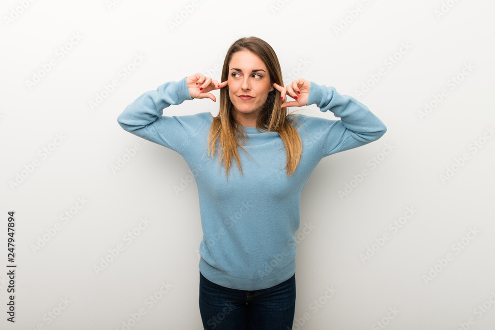 Blonde woman on isolated white background covering both ears with hands Blonde woman on isolated white background covering both ears with hands