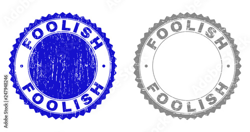 Grunge FOOLISH stamp seals isolated on a white background. Rosette seals with grunge texture in blue and gray colors. Vector rubber stamp imitation of FOOLISH label inside round rosette.