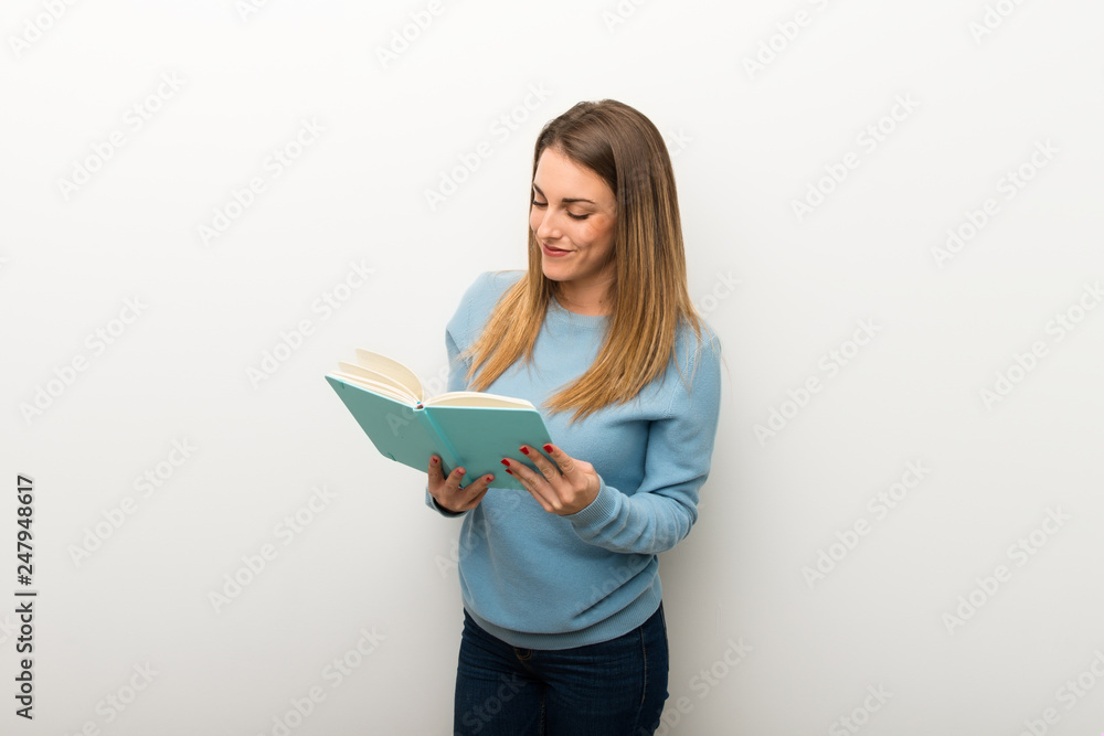 Blonde woman on isolated white background holding a book and enjoying reading Blonde woman on isolated white background holding a book and enjoying reading