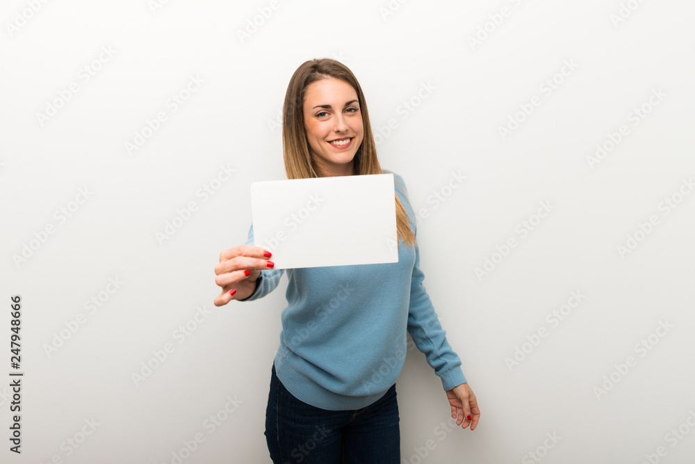 Blonde woman on isolated white background holding an empty white placard Blonde woman on isolated white background holding an empty white placard