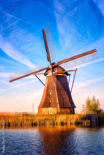 Amazing nature, scenic sunset landscape, windmills, blue sky and water. Traditional dutch countryside, famous village of mills Kinderdijk, popular tourist attraction in Netherlands (Holland). Vertical