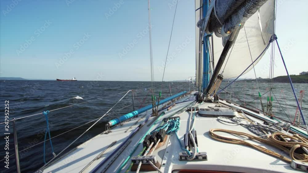 View of the yacht nose (with marine tackle) that is sailing along the Peter the Great Gulf taking part in regatta. Vladivostok, Russia. Beautiful blue sea of Japan View of the yacht nose (with marine tackle) that is sailing along the Peter the Great Gulf taking part in regatta. Vladivostok, Russia. Beautiful blue sea of Japan