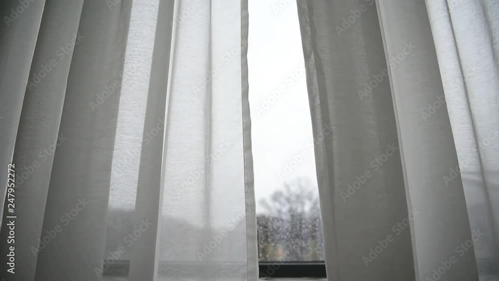 White window curtain blown by the wind shot against outdoor light White window curtain blown by the wind shot against outdoor light