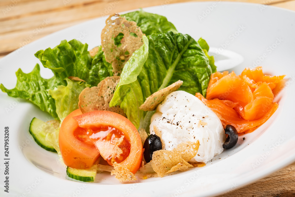 salad with mozzarella and salmon, wooden background salad with mozzarella and salmon, wooden background