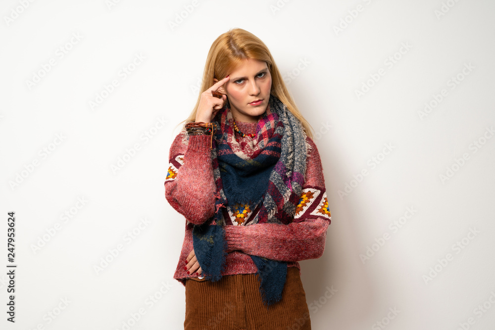 Hippie woman over white wall having doubts and thinking Hippie woman over white wall having doubts and thinking