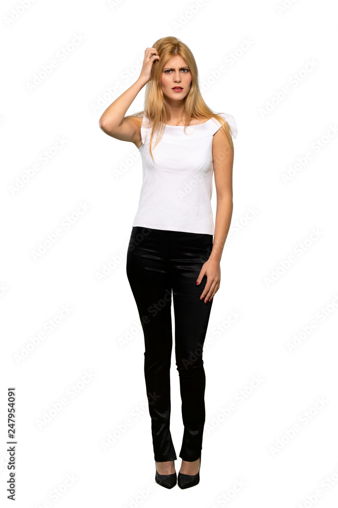 Young blonde woman having doubts while scratching head over isolated white background Young blonde woman having doubts while scratching head over isolated white background