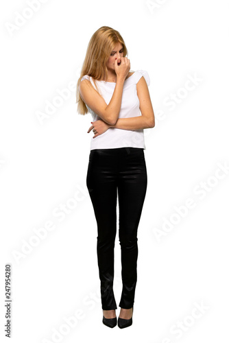 Young blonde woman having doubts over isolated white background © luismolinero