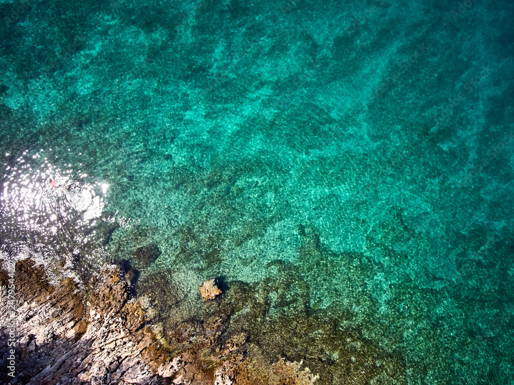 top view of rocky shore crystal clear Adriatic Sea, drone shot