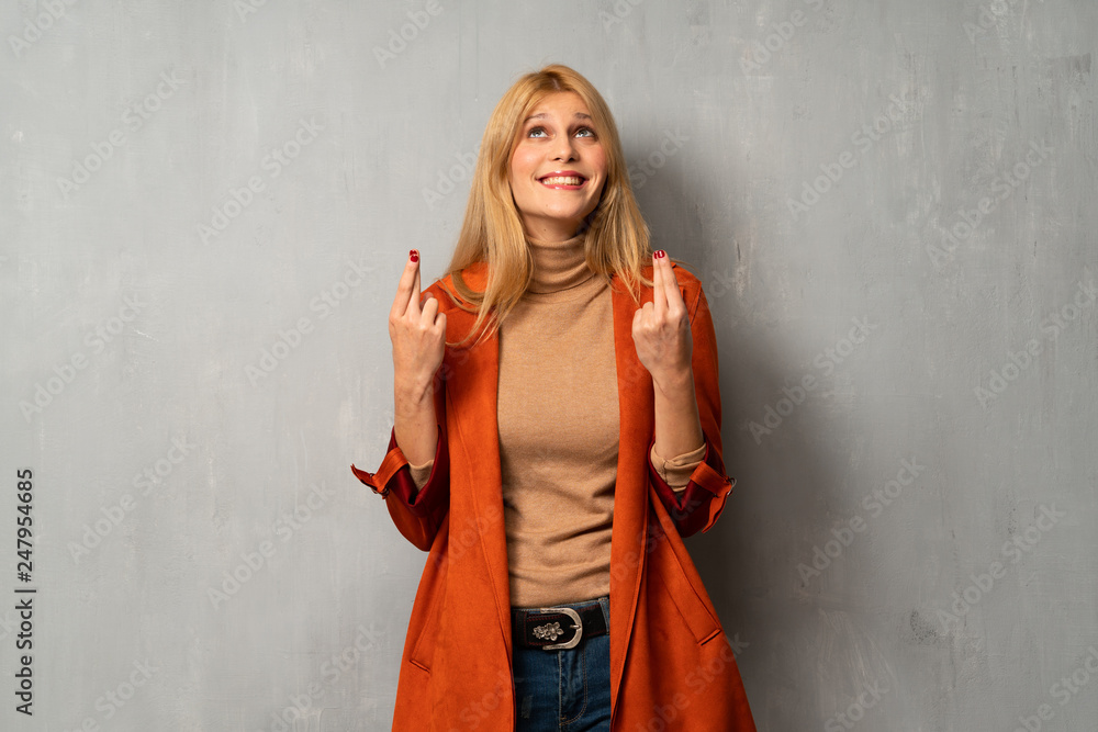 Woman over textured background with fingers crossing and wishing the best Woman over textured background with fingers crossing and wishing the best