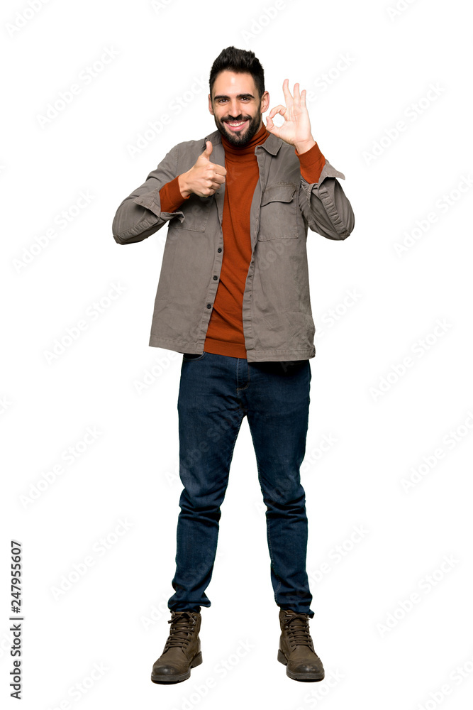 Full-length shot of Handsome man with beard showing ok sign with and giving a thumb up gesture on isolated white background Full-length shot of Handsome man with beard showing ok sign with and giving a thumb up gesture on isolated white background
