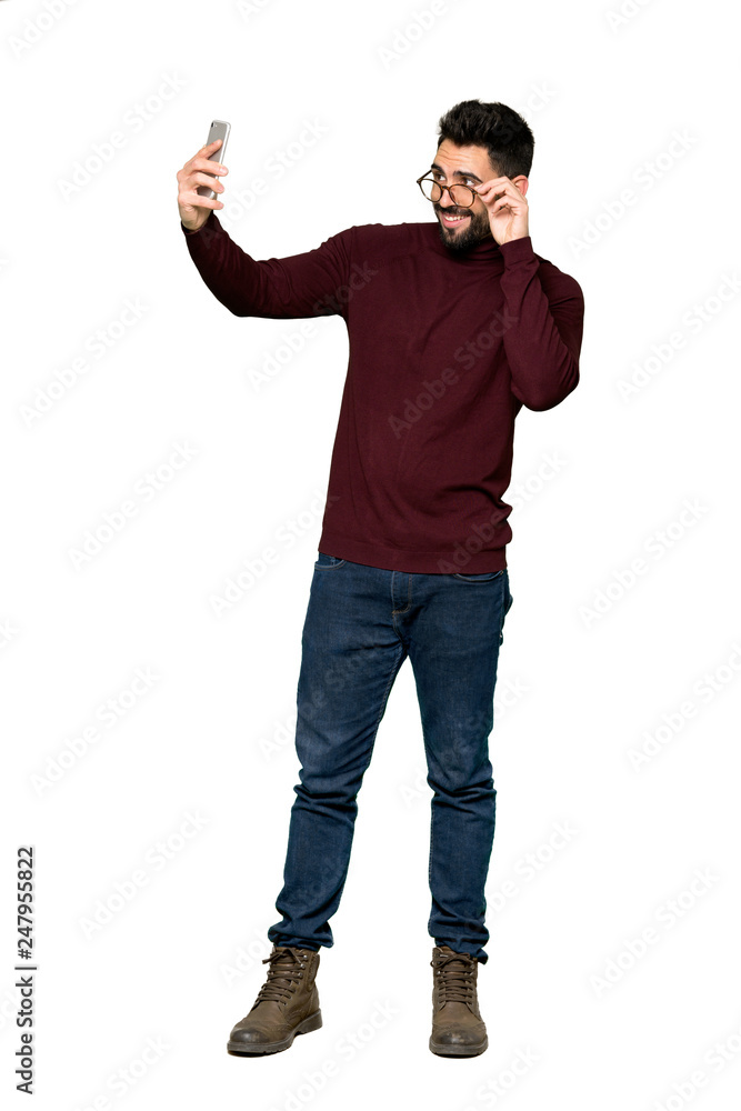 Full-length shot of Handsome man with glasses making a selfie on isolated white background Full-length shot of Handsome man with glasses making a selfie on isolated white background
