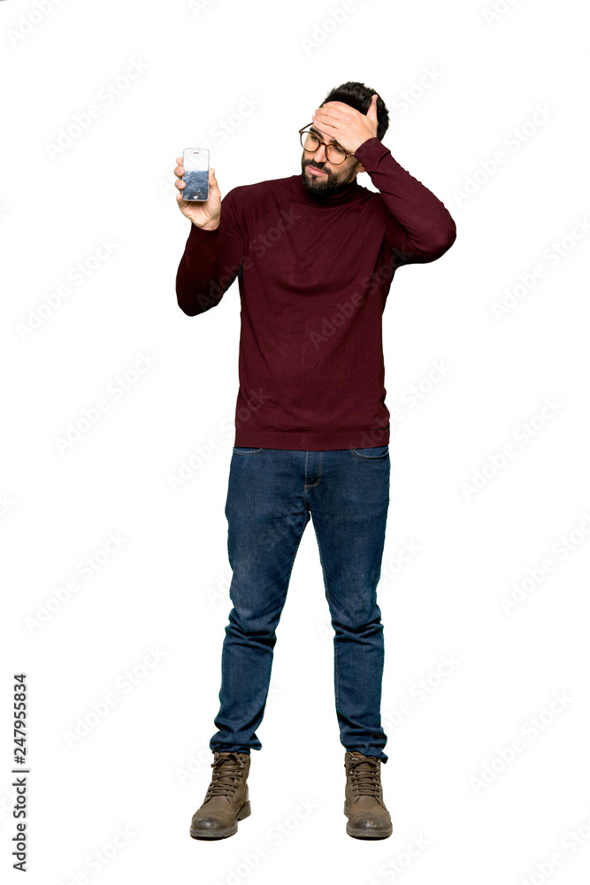Full-length shot of Handsome man with glasses with troubled holding broken smartphone on isolated white background Full-length shot of Handsome man with glasses with troubled holding broken smartphone on isolated white background