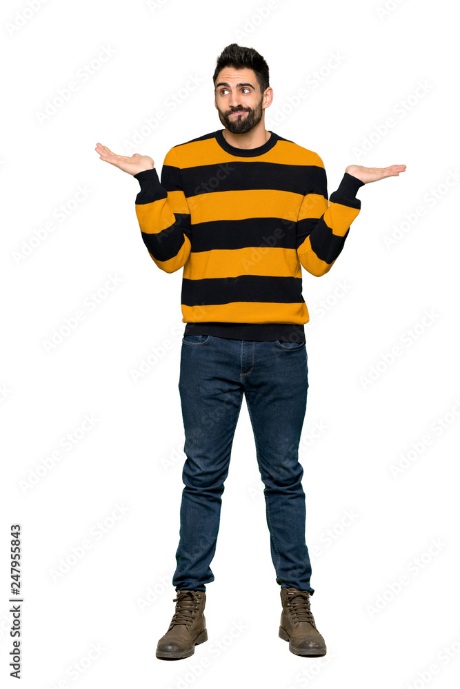 Full-length shot of Handsome man with striped sweater having doubts while raising hands and shoulders on isolated white background Full-length shot of Handsome man with striped sweater having doubts while raising hands and shoulders on isolated white background