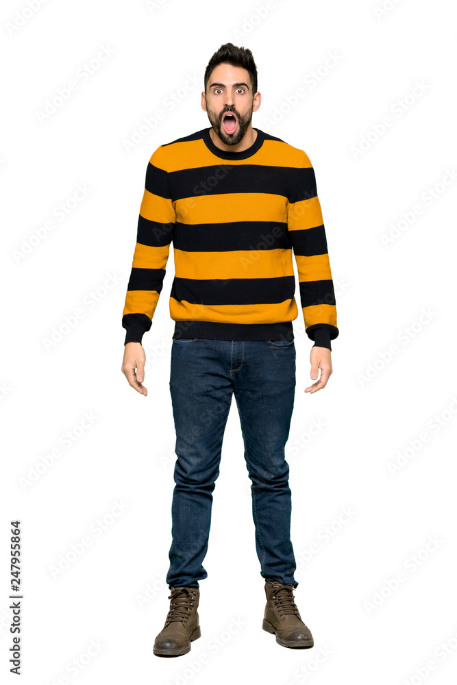 Full-length shot of Handsome man with striped sweater with surprise and shocked facial expression on isolated white background Full-length shot of Handsome man with striped sweater with surprise and shocked facial expression on isolated white background