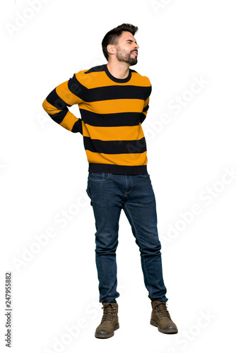 Full-length shot of Handsome man with striped sweater suffering from backache for having made an effort on isolated white background