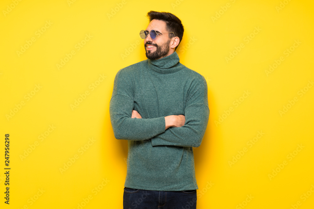 Handsome man with sunglasses keeping the arms crossed while smiling Handsome man with sunglasses keeping the arms crossed while smiling