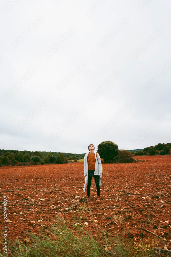 Middle age woman alone in nature in a cold autumn day