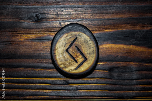 Rune Jera (Jeran, Jeraz) carved from wood on a wooden background - Elder Futhark photo