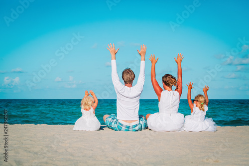 happy family with kids hands up on beach