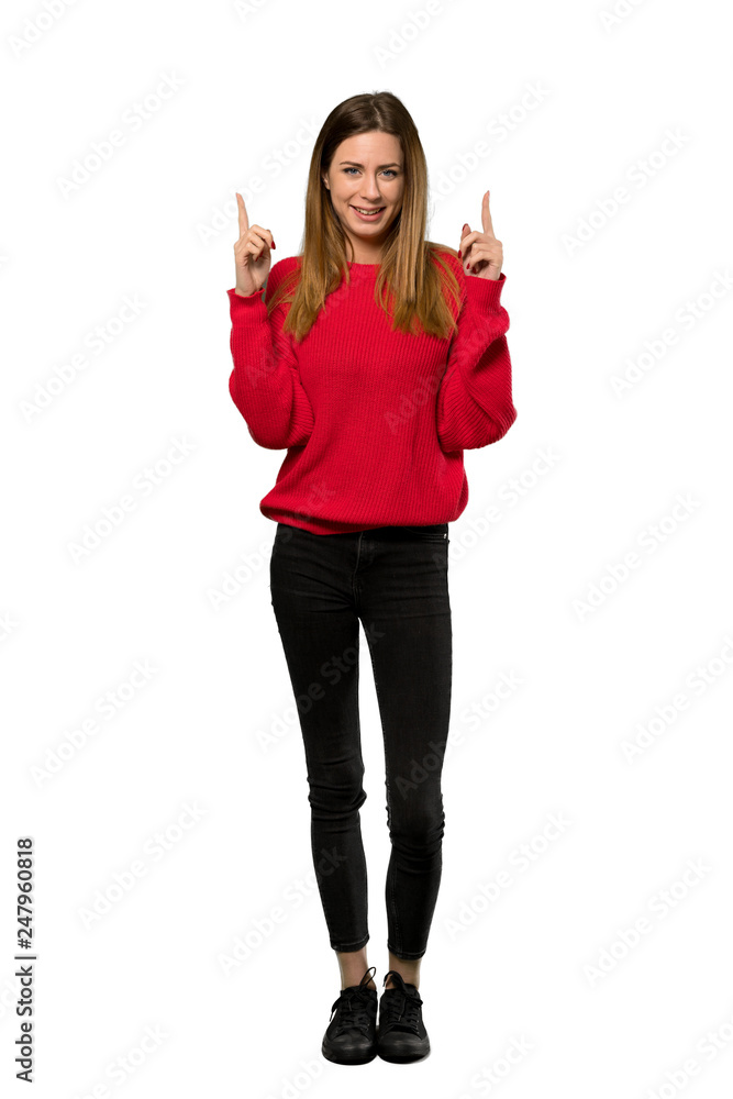A full-length shot of a Young woman with red sweater pointing with the index finger a great idea over isolated white background A full-length shot of a Young woman with red sweater pointing with the index finger a great idea over isolated white background