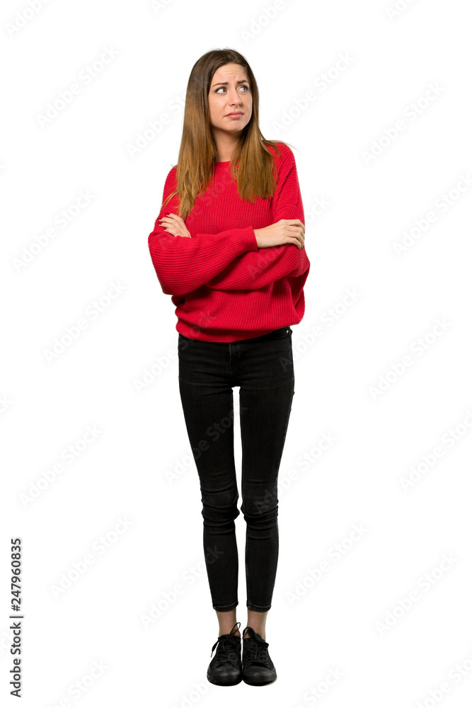 A full-length shot of a Young woman with red sweater making doubts gesture while lifting the shoulders over isolated white background A full-length shot of a Young woman with red sweater making doubts gesture while lifting the shoulders over isolated white background