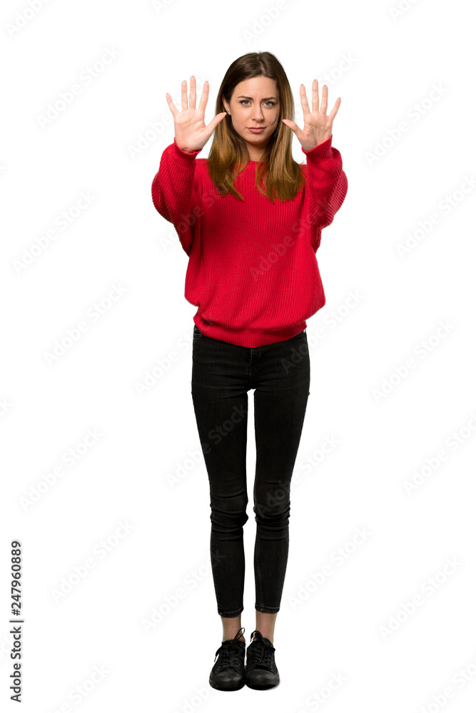 A full-length shot of a Young woman with red sweater counting ten with fingers over isolated white background A full-length shot of a Young woman with red sweater counting ten with fingers over isolated white background