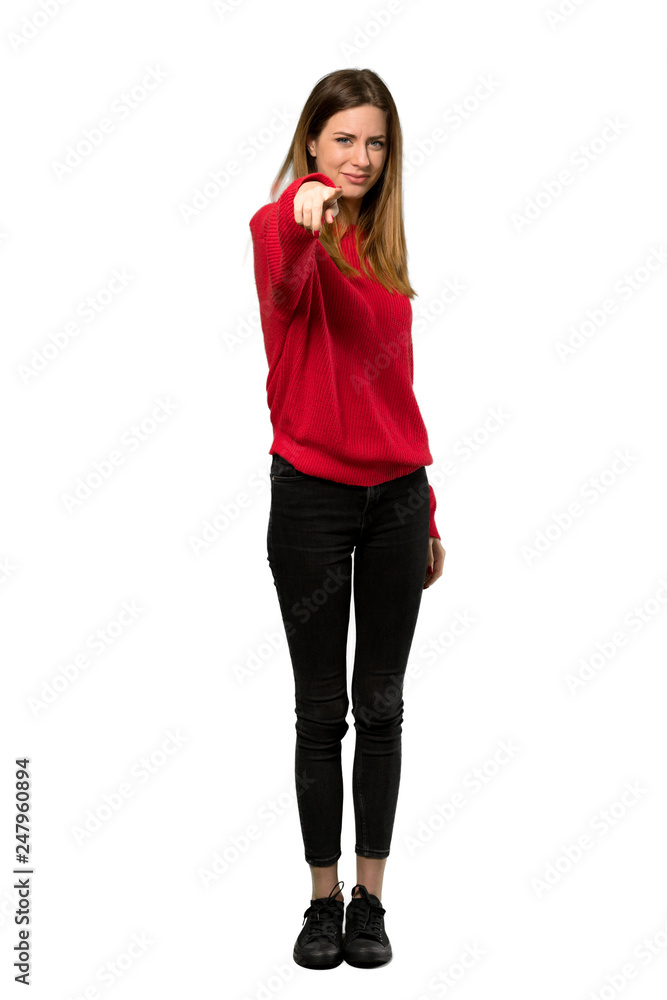 A full-length shot of a Young woman with red sweater points finger at you with a confident expression over isolated white background A full-length shot of a Young woman with red sweater points finger at you with a confident expression over isolated white background