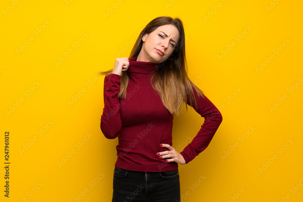 Woman with turtleneck over yellow wall with tired and sick expression Woman with turtleneck over yellow wall with tired and sick expression