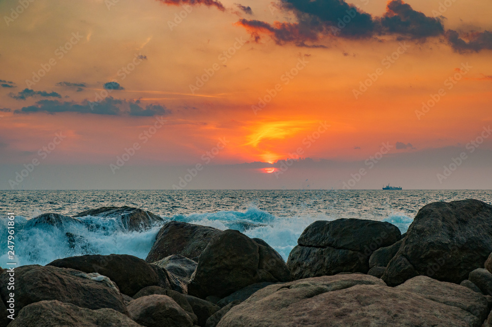 Ocean waves breaking on the rocks at sunset. Sunset in the ocean with waves breaking on the rocks. Ocean waves breaking on the rocks at sunset. Sunset in the ocean with waves breaking on the rocks.