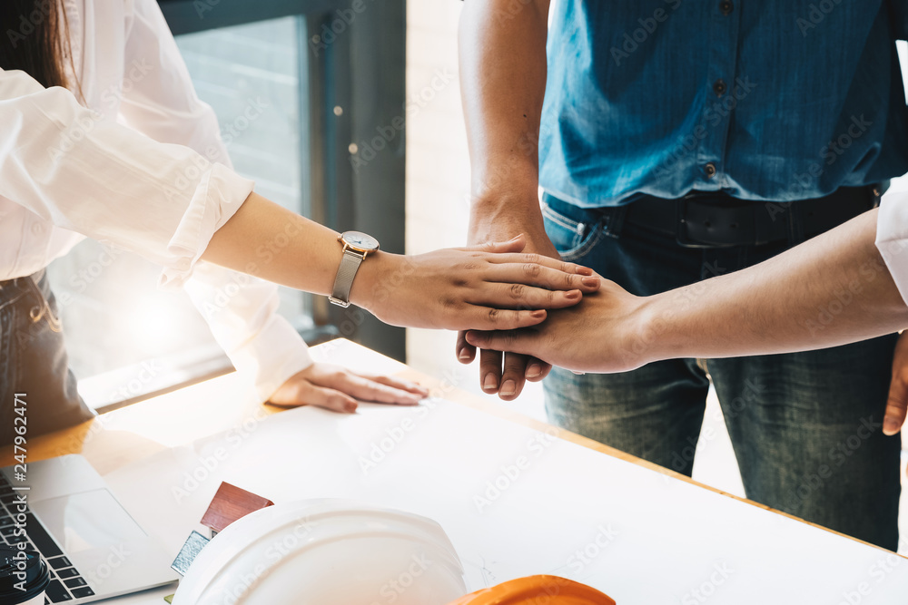 Businessmen and engineers join hands to build successful projects. Teamwork concept