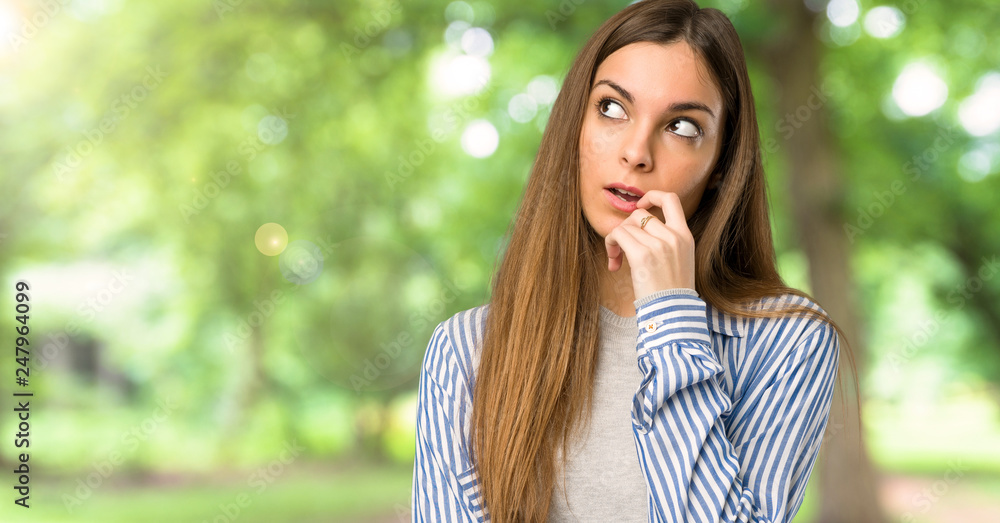 Young girl with striped shirt having doubts while looking up at outdoors Young girl with striped shirt having doubts while looking up at outdoors