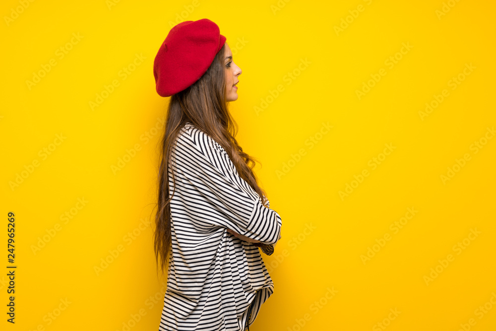 Girl with french style over yellow wall in lateral position Girl with french style over yellow wall in lateral position